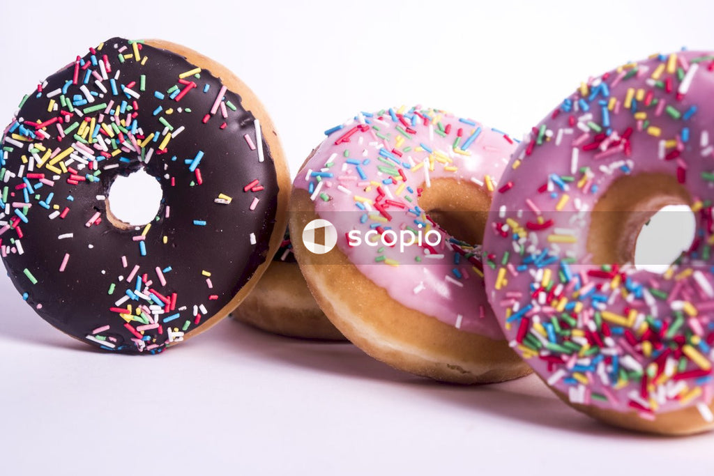 Chocolate doughnut with sprinkles on white surface