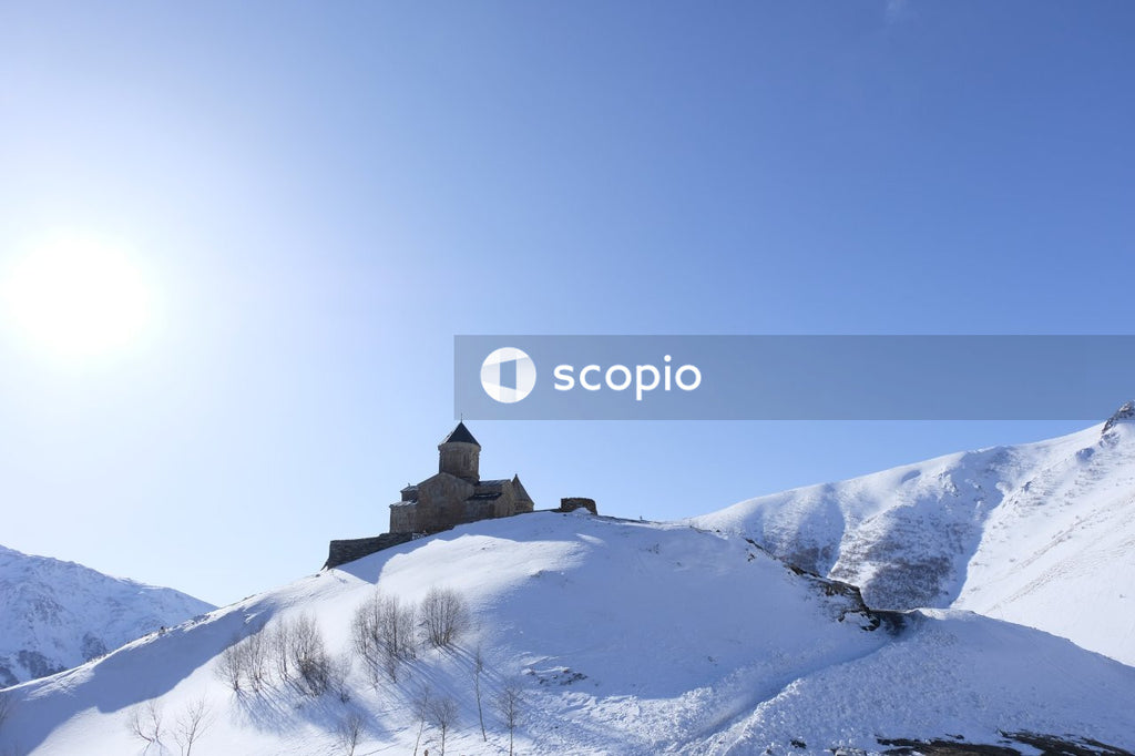 Black and white house on snow covered mountain under blue sky