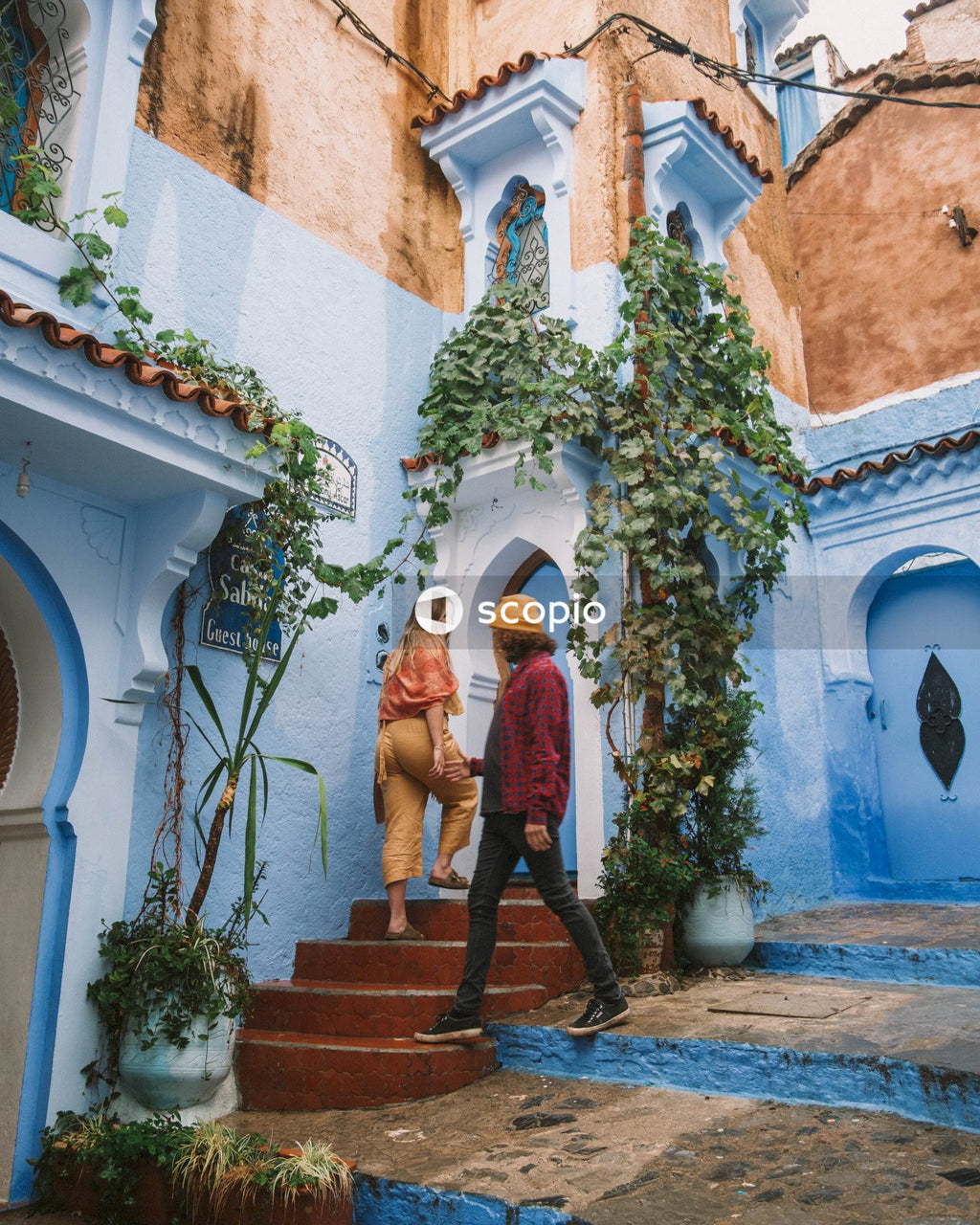 Man and woman standing on doorstep of a house in Chefchaouen, Morocco