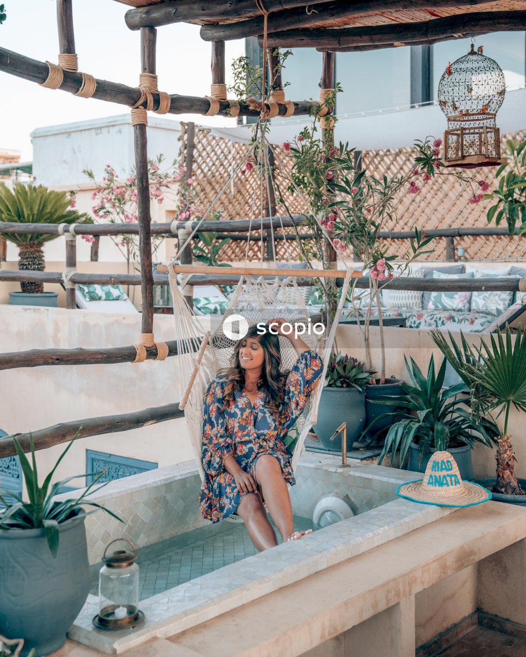 Woman in floral dress sitting on hanging chair