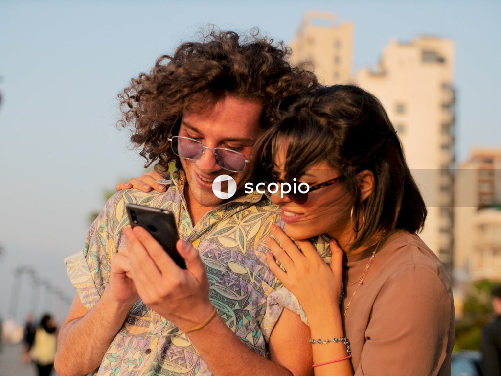 Woman and man holding each other and looking at a phone