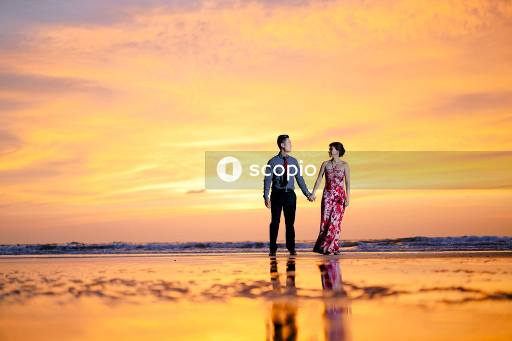 Couple walking on beach during sunset
