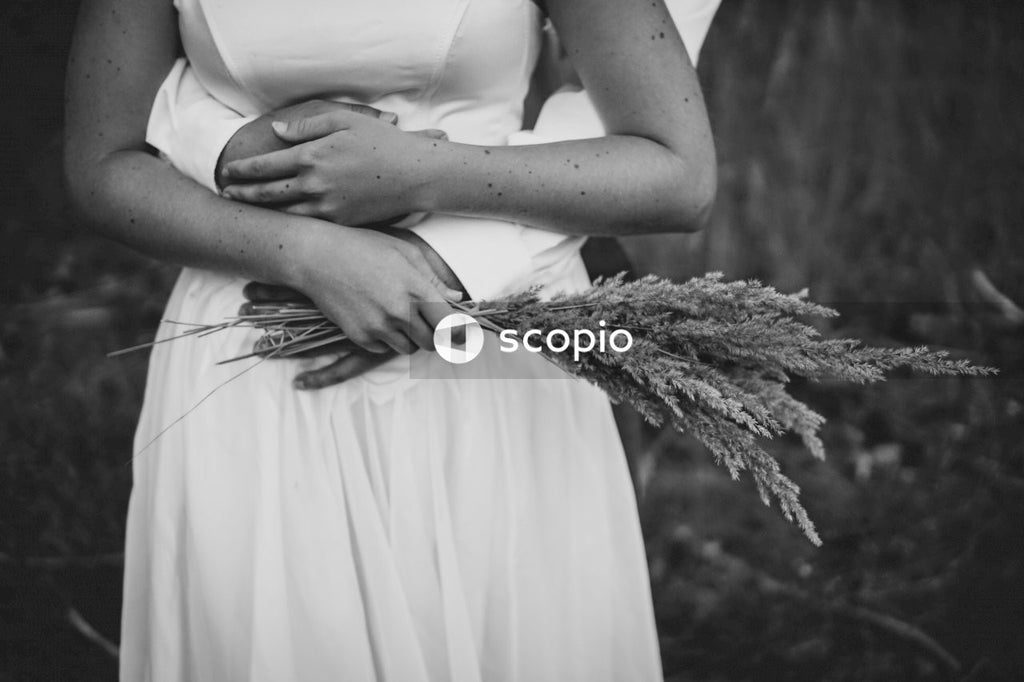 Monochrome picture of cropped bride and groom hugging