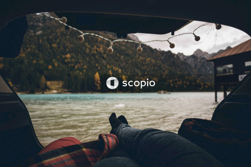 Cropped image if person sitting in a tent by the lake at sunset