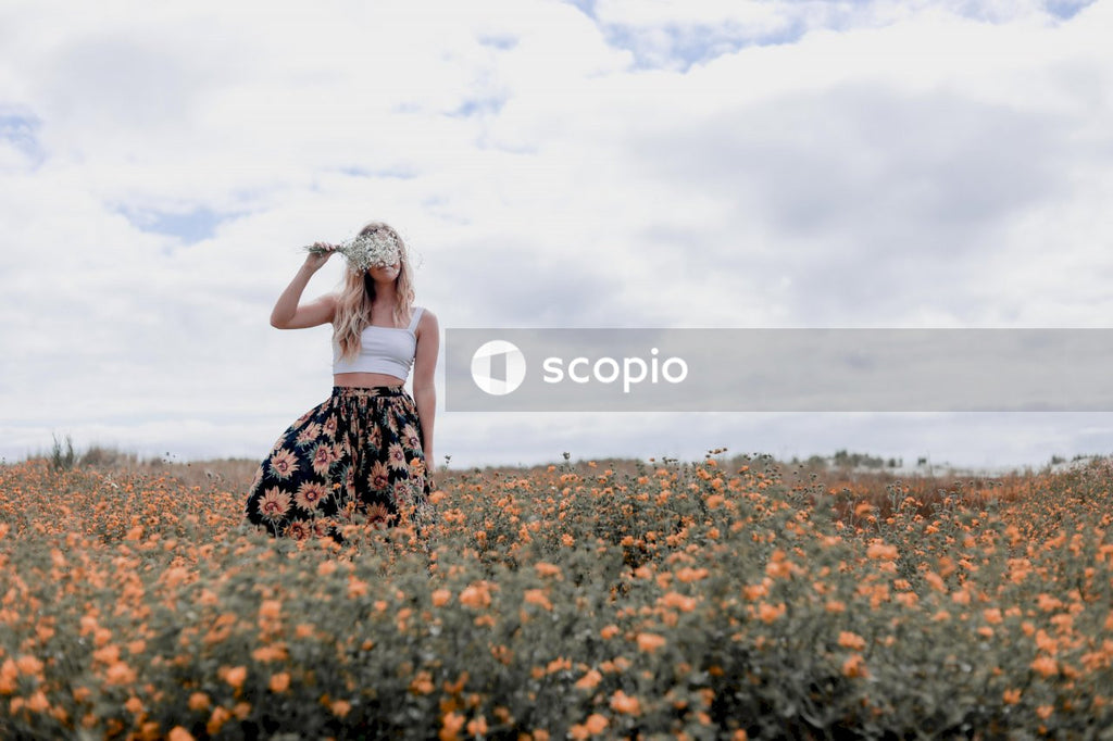Woman in black and white floral dress standing on flower field