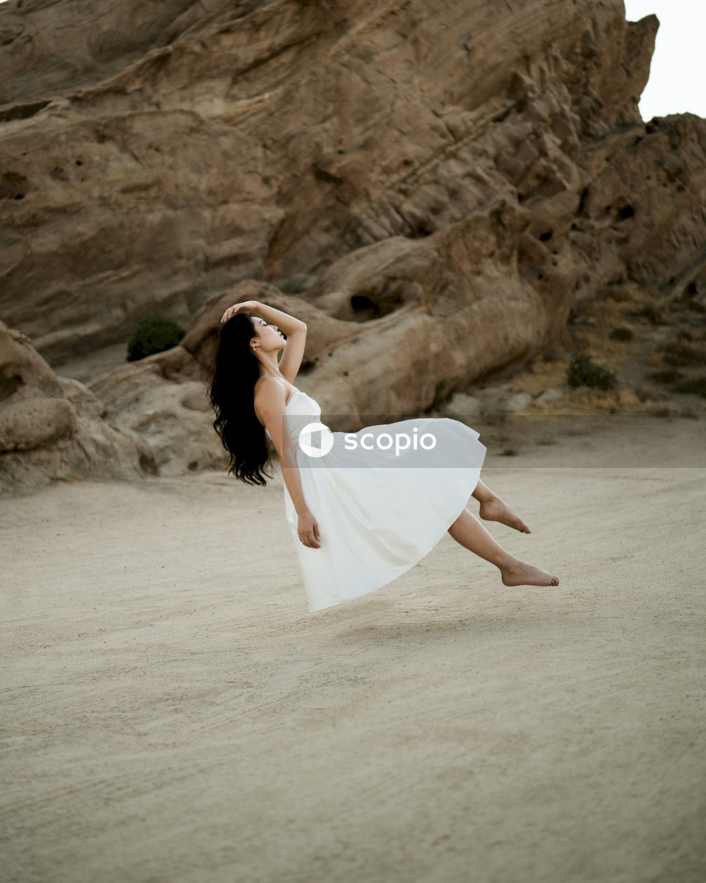 Woman in short light dress standing on sandy shore