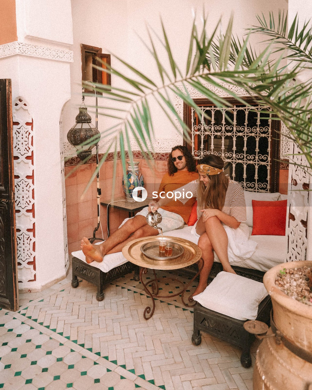 Man and woman sitting and drinking tea in Moroccan style interior