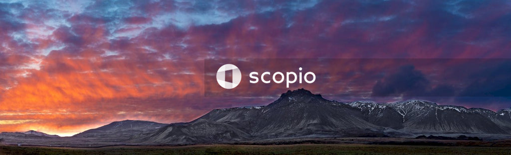 Black mountain under orange and gray sky