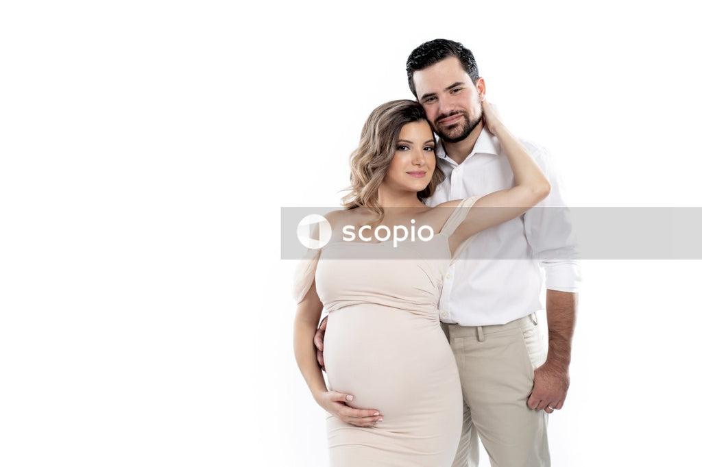 Woman in white dress hugging man in white dress shirt