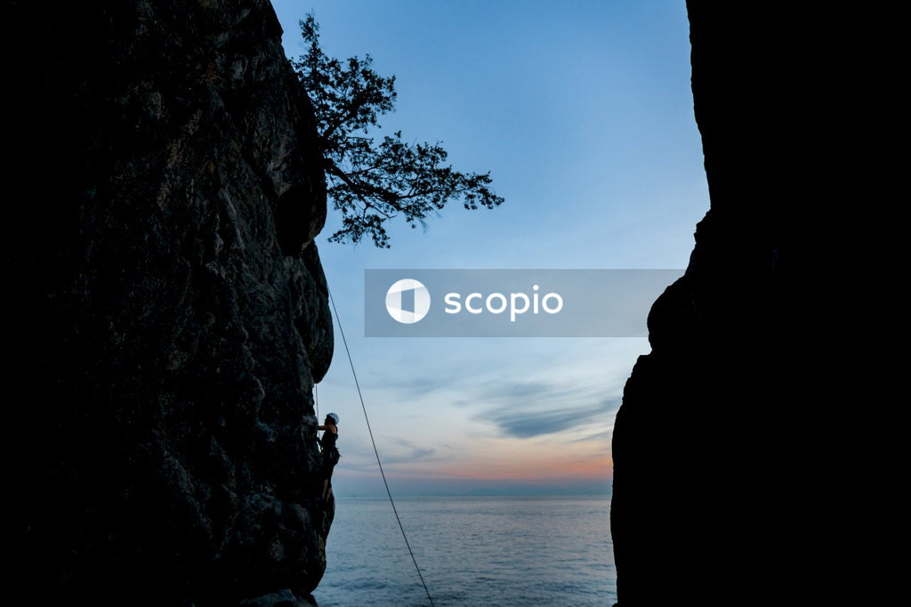 Silhouette of person climbing mountain