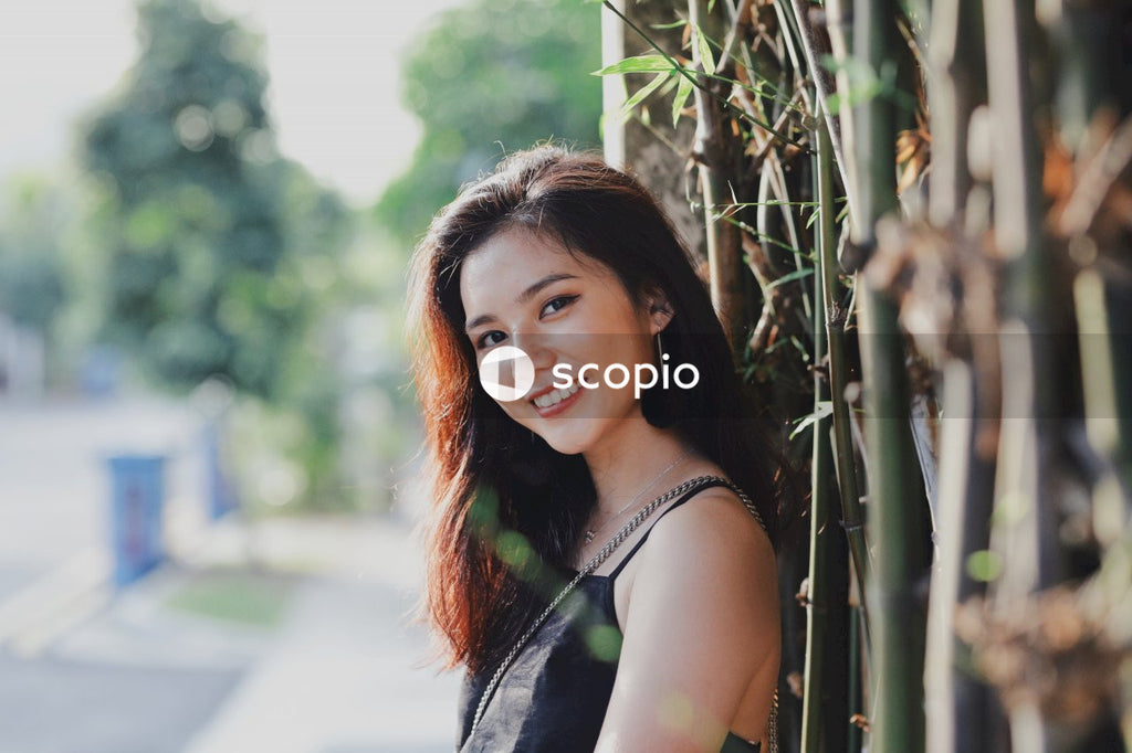 Woman in dark dress posing near flowers bushes