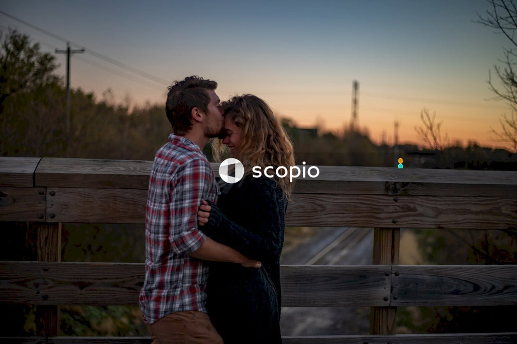Man and woman standing beside wooden fence during sunset