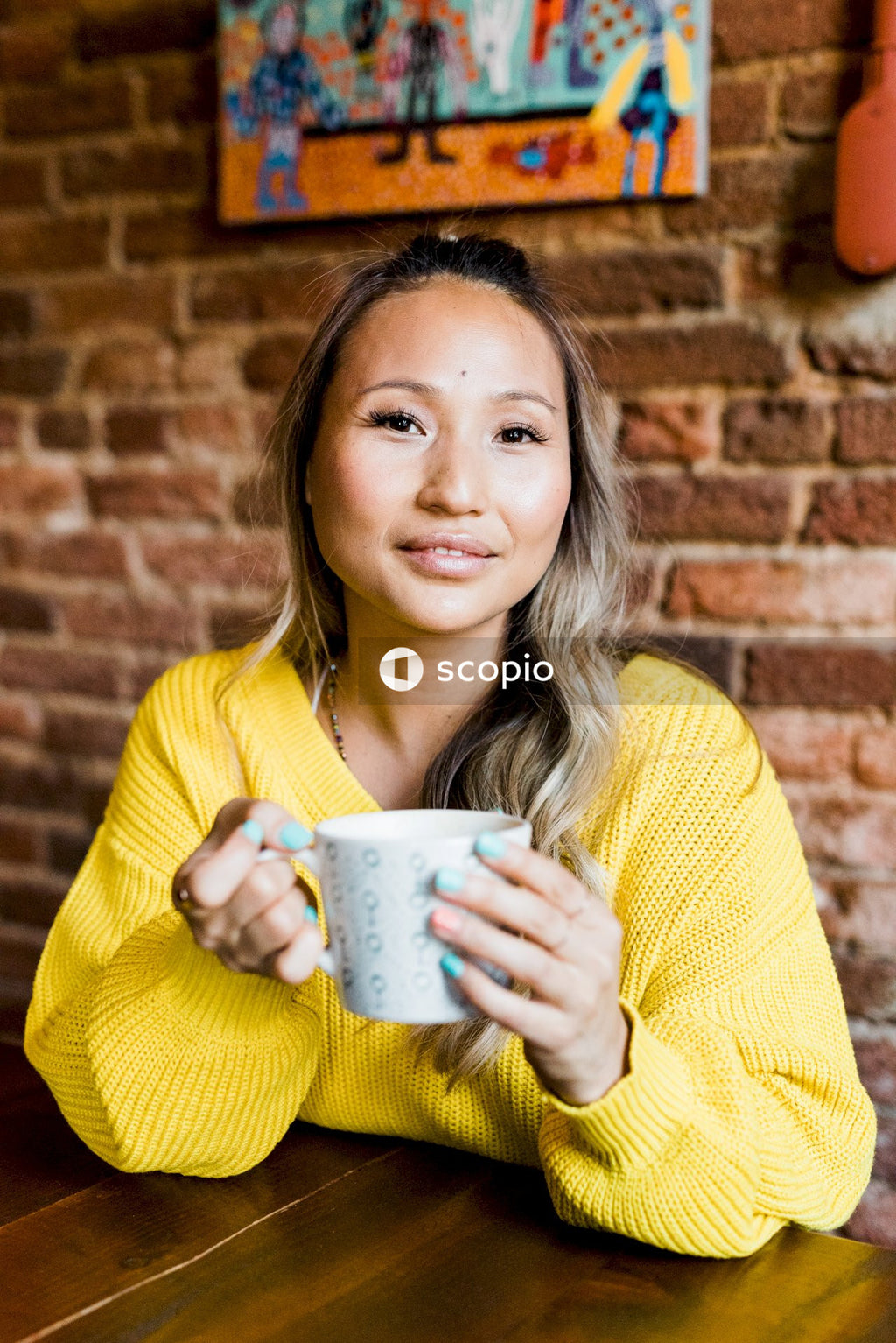 Woman in yellow sweater holding ceramic mug