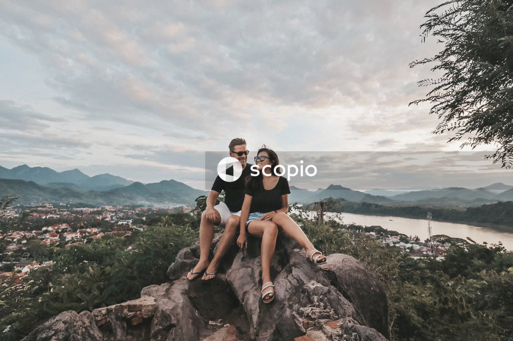 Couple sitting on rocks on mountainous landform