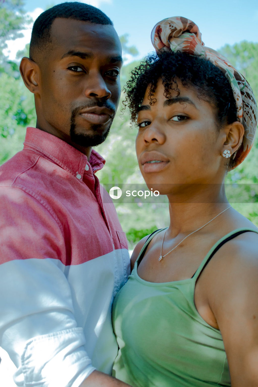 Black couple hugging near trees