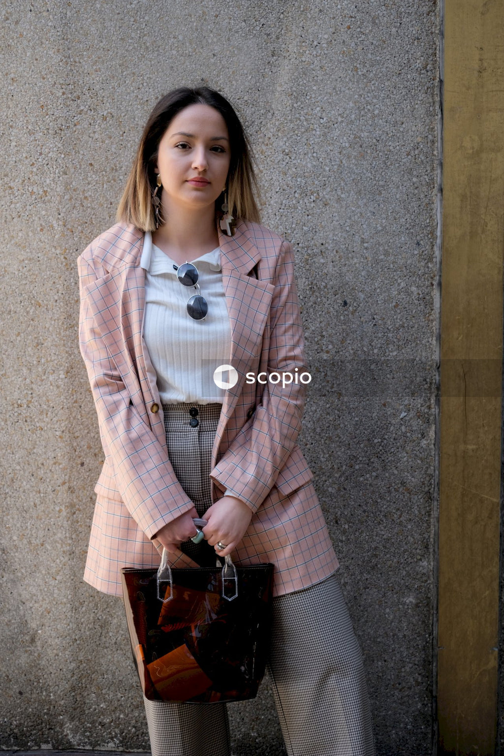Woman in brown coat holding brown leather bag