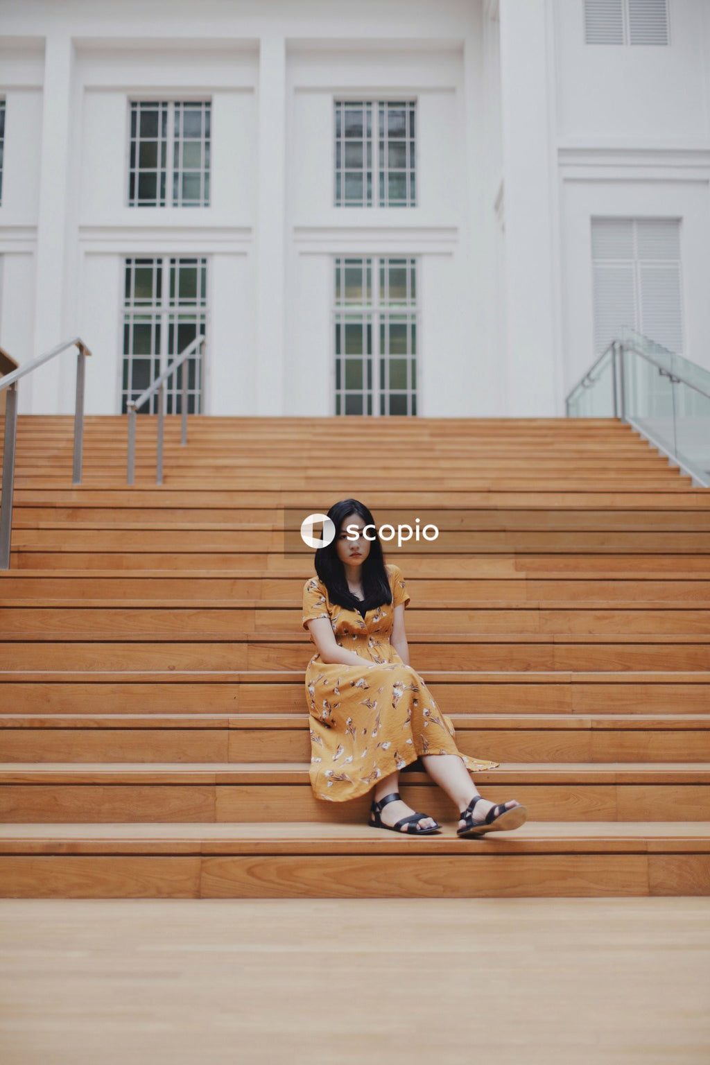 Woman in orange dress sitting on stairs