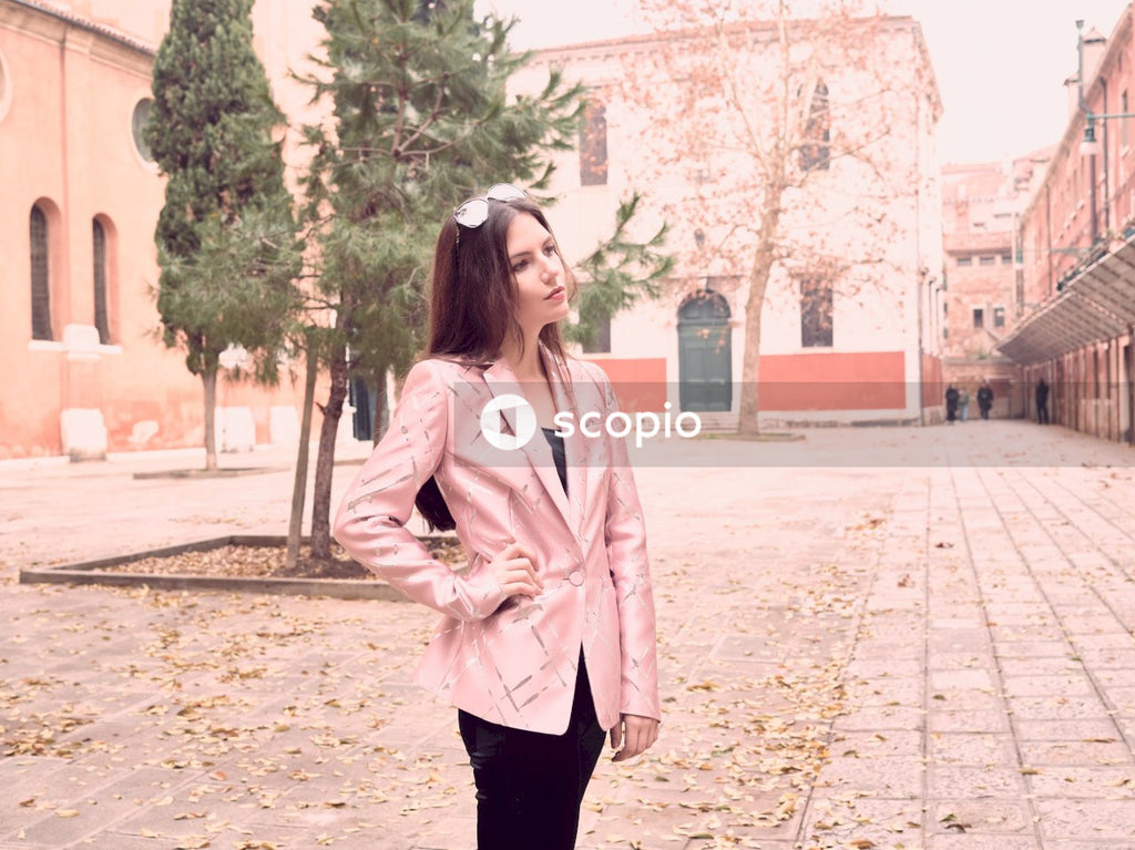 Standing woman holding her hip with right hand near green leafed trees