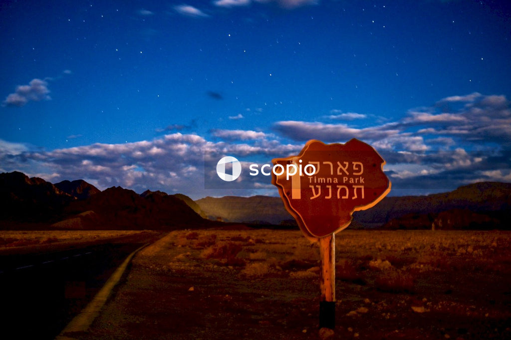 Red stop road sign on brown field under blue sky
