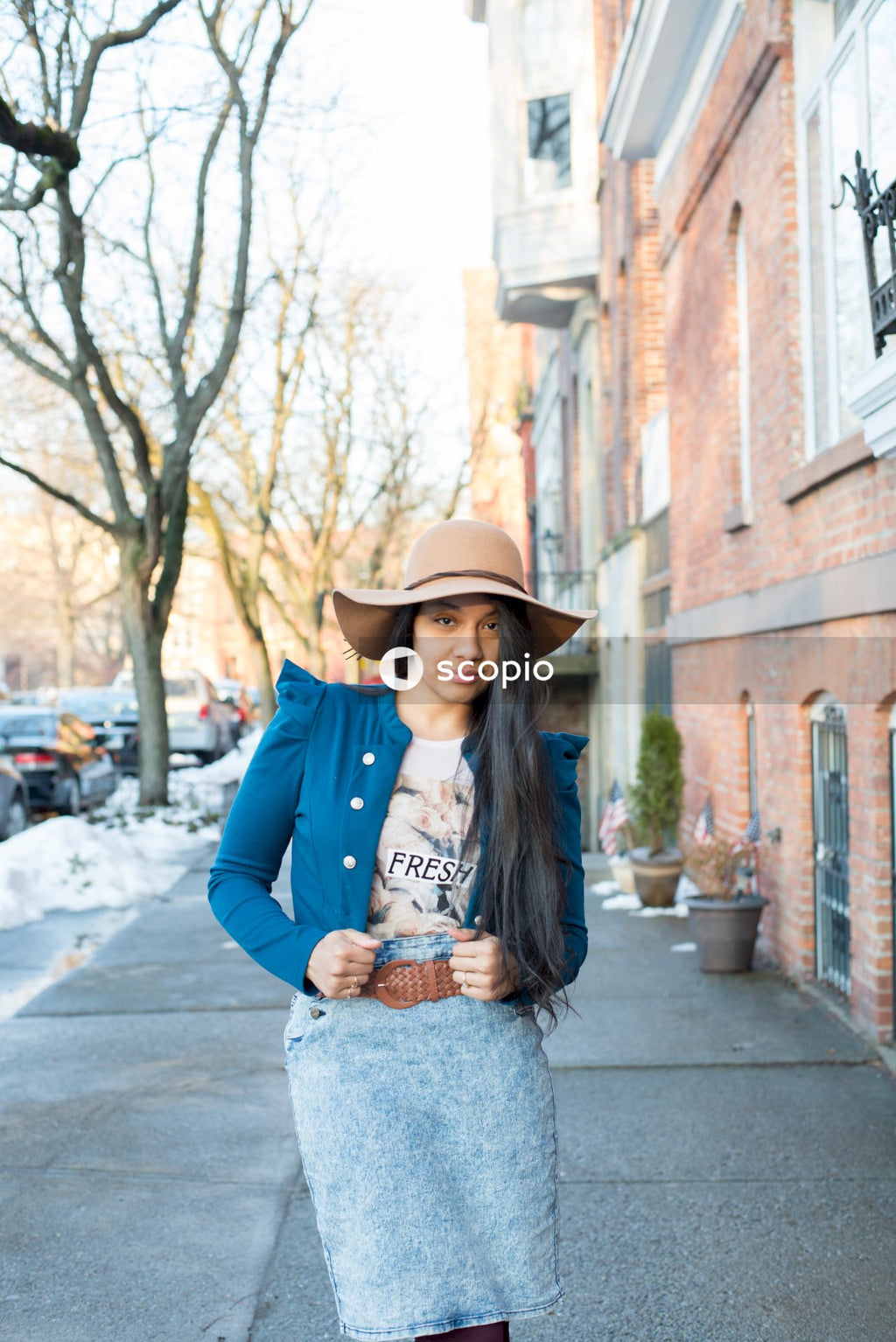 Woman wearing fedora hat standing on sidewalk