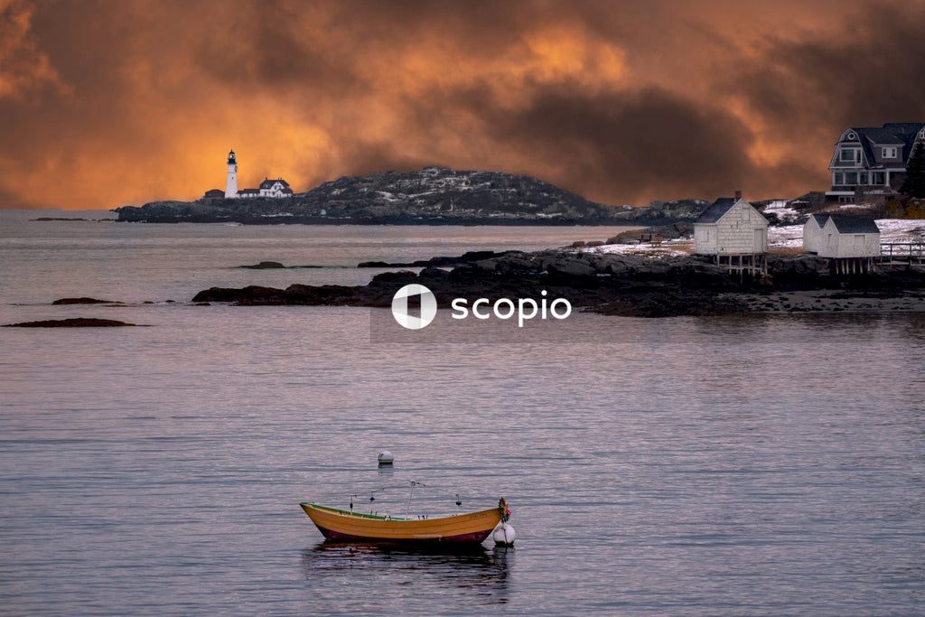 Sunset over bay with boat and lighthouse