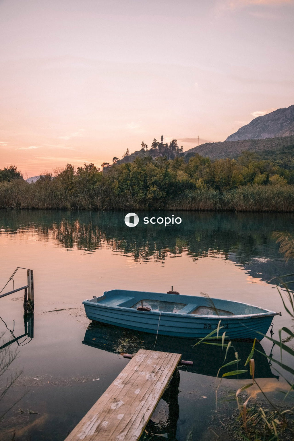 Blue boat of calm body of water during sunset