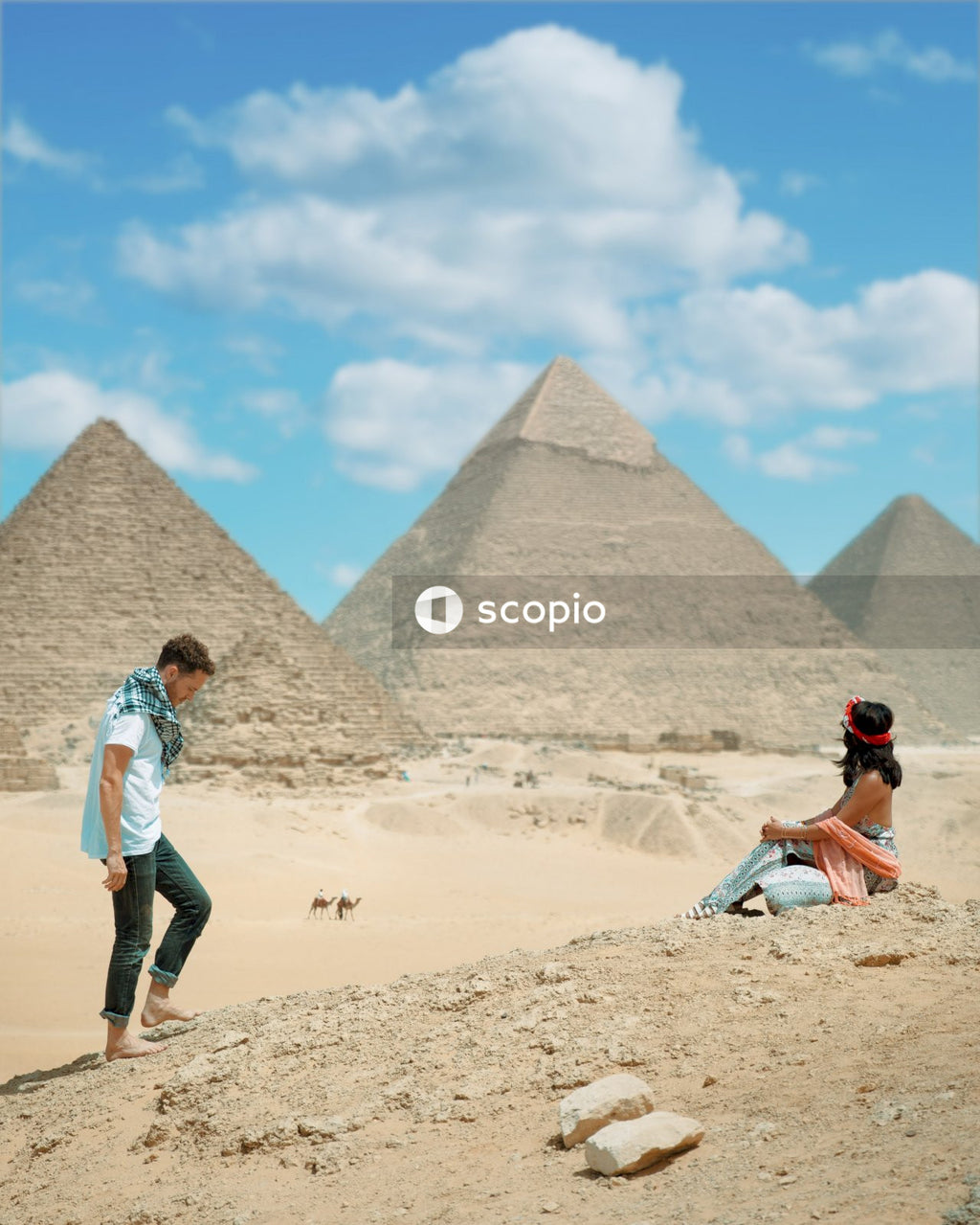 Couple relaxing near giza pyramids, egypt