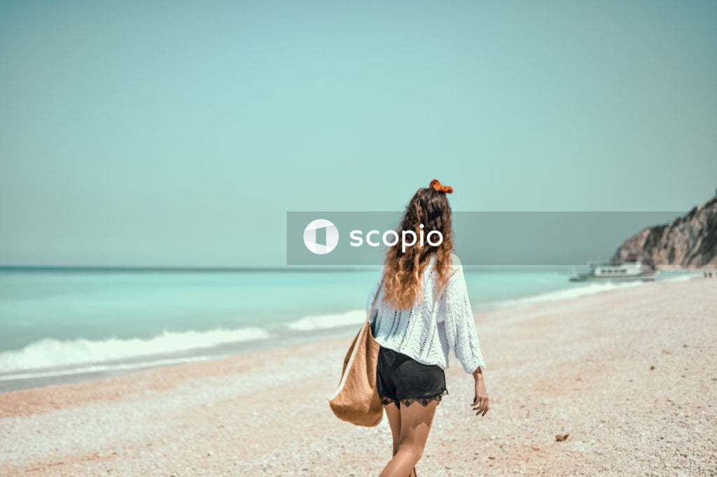Woman in white and blue long sleeve dress walking on beach