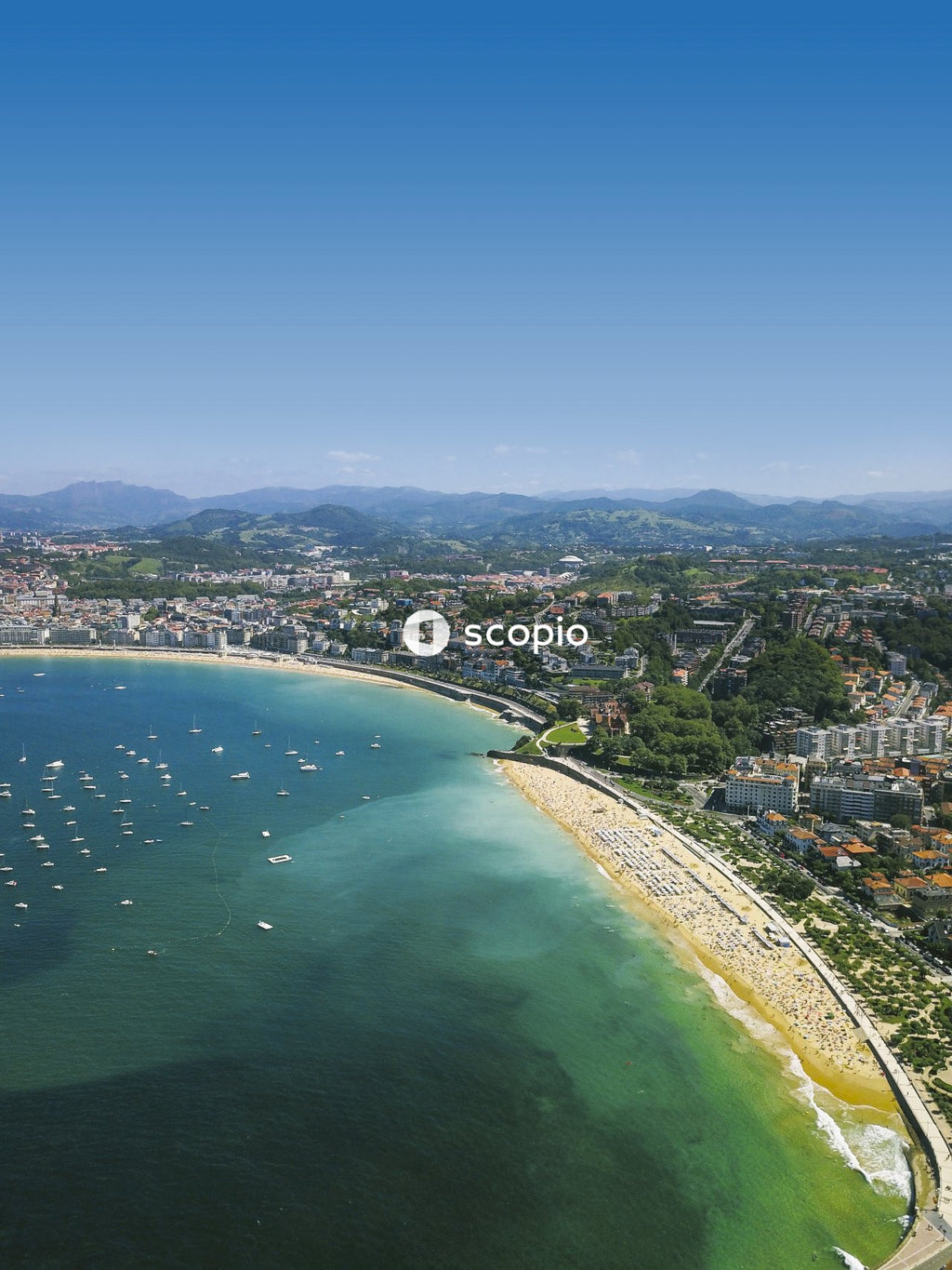 Stunning Panorama Of  City by the Sea With Hills Boats and Beachgoers