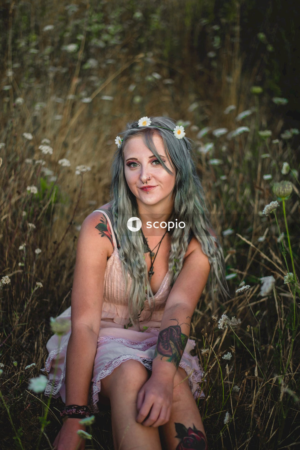 Woman in brown tank top sitting on grass field
