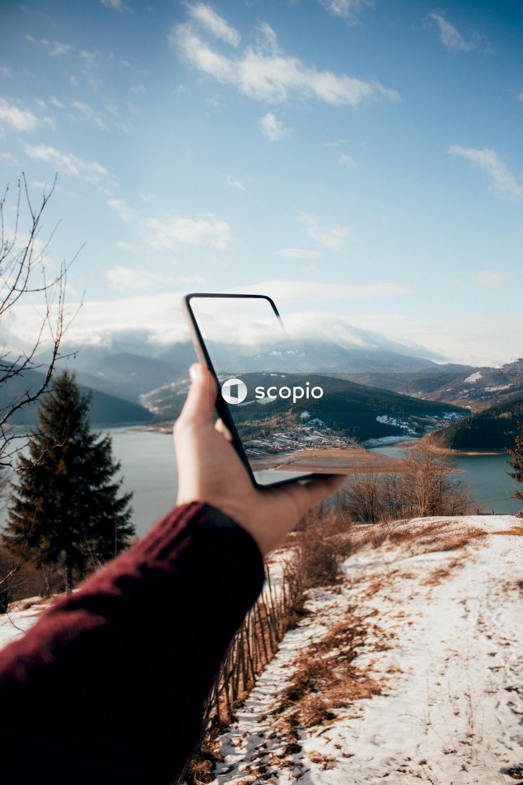 Person holding smartphone in front of mountain