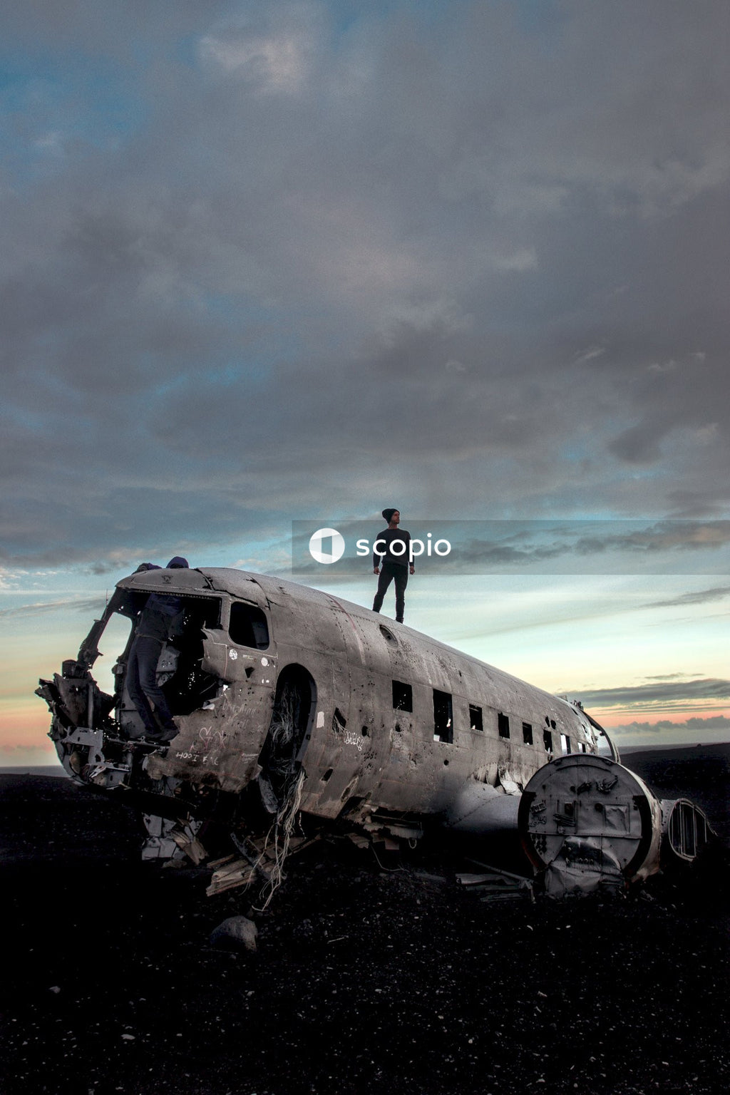 Man standing on wrecked airplane in the middle of nowhere
