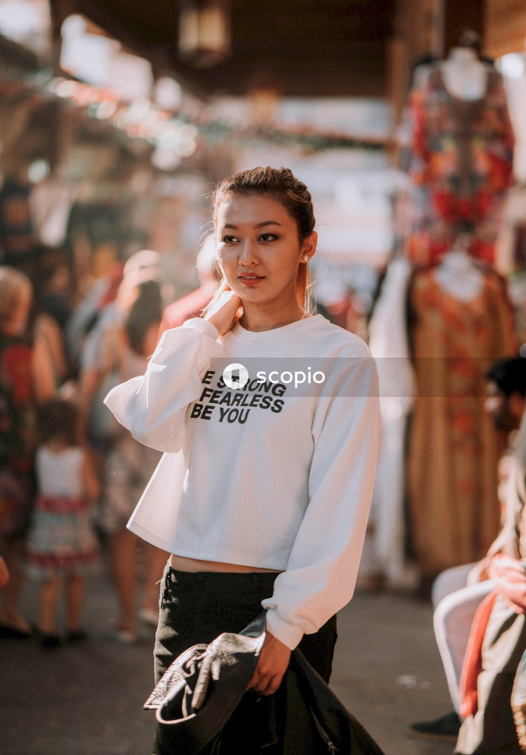 Woman in white long sleeve shirt standing and smiling