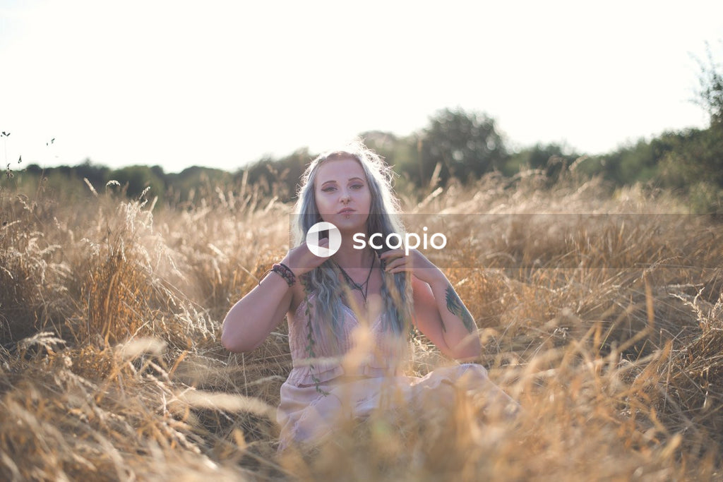 Woman in brown and white plaid shirt standing on brown grass field