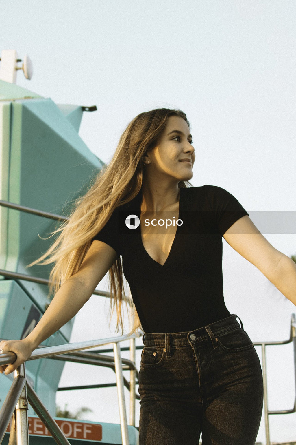 Woman in Black Scoop Neck Shirt and Denim Enjoying the Weather