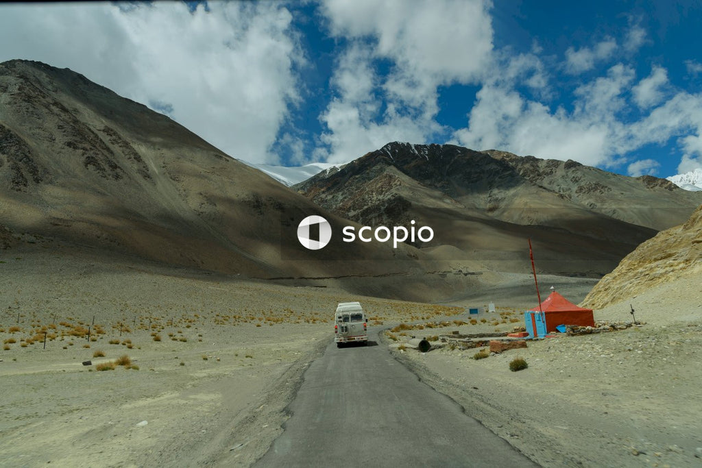 White van on road near mountain under blue sky