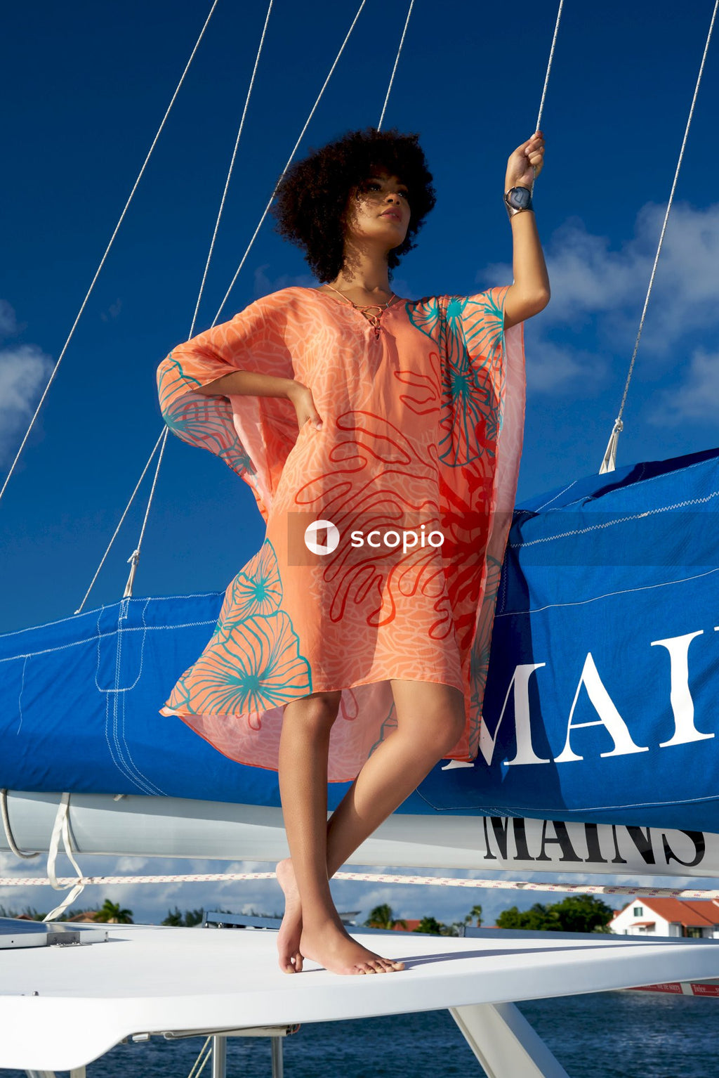 Woman in orange floral dress standing on yacht roof