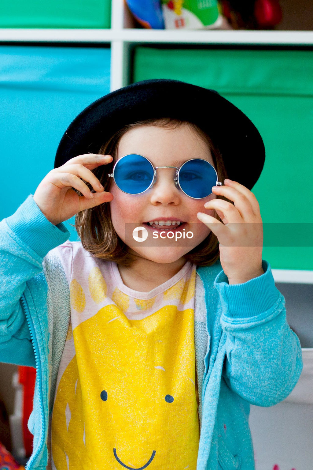 Young girl wearing blue sunglasses and hat