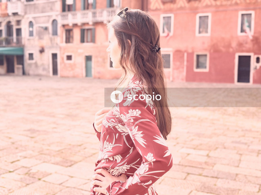 Woman in red and white floral dress standing on brown concrete floor