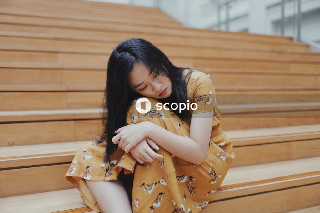 Woman in orange dress sitting on stairs