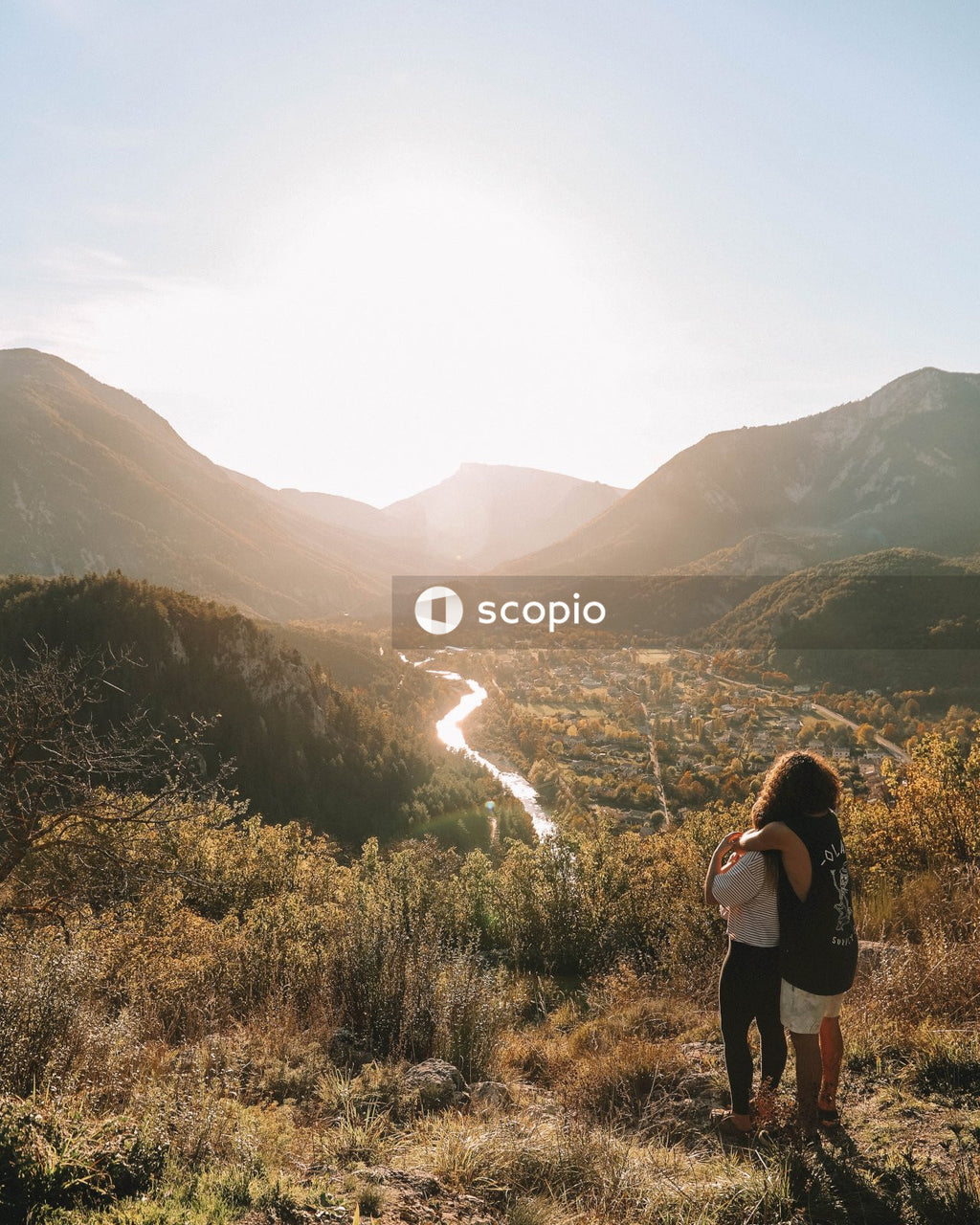 Man and woman hugging near mountains