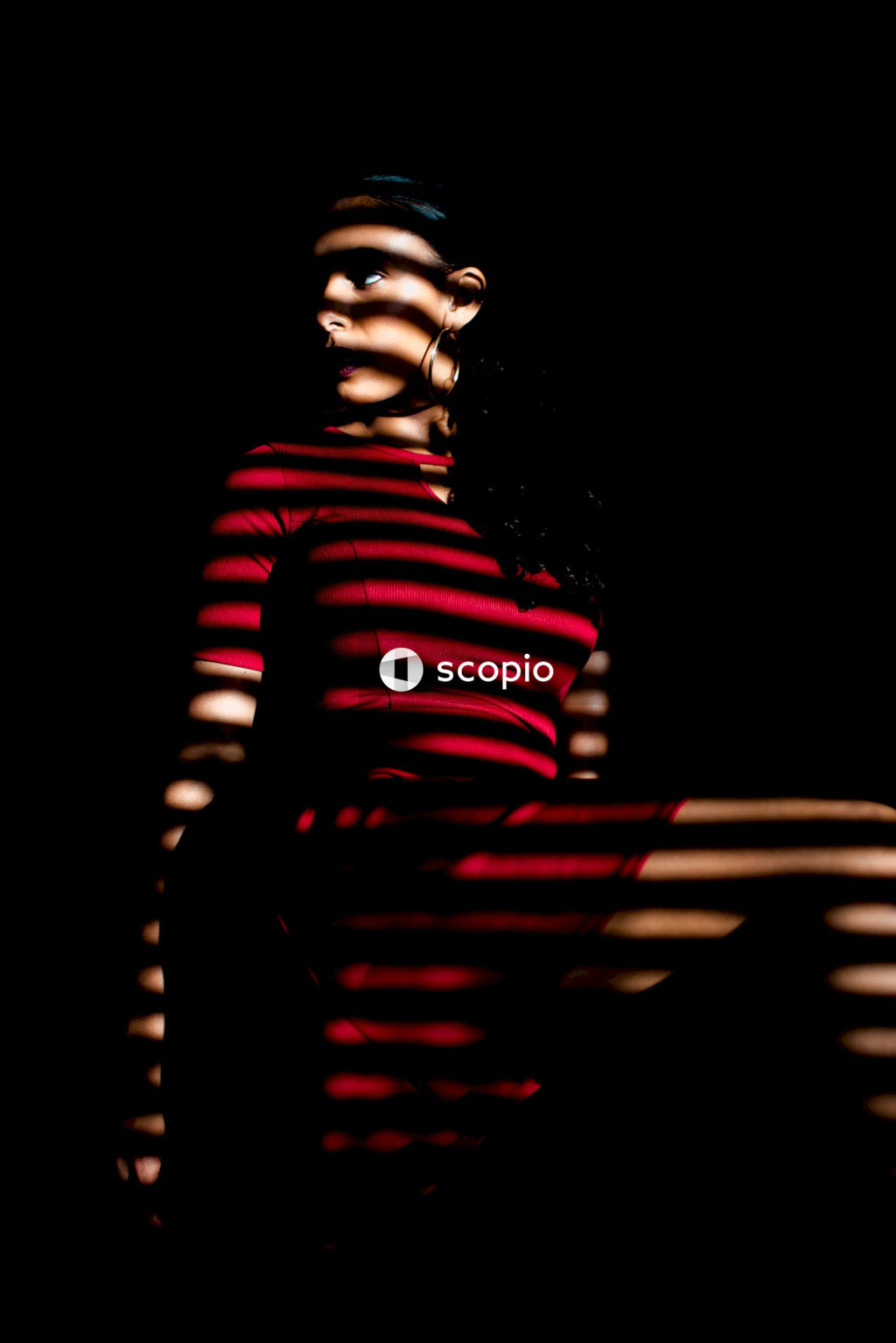 Woman wearing mini red dress with slanted shadow over her
