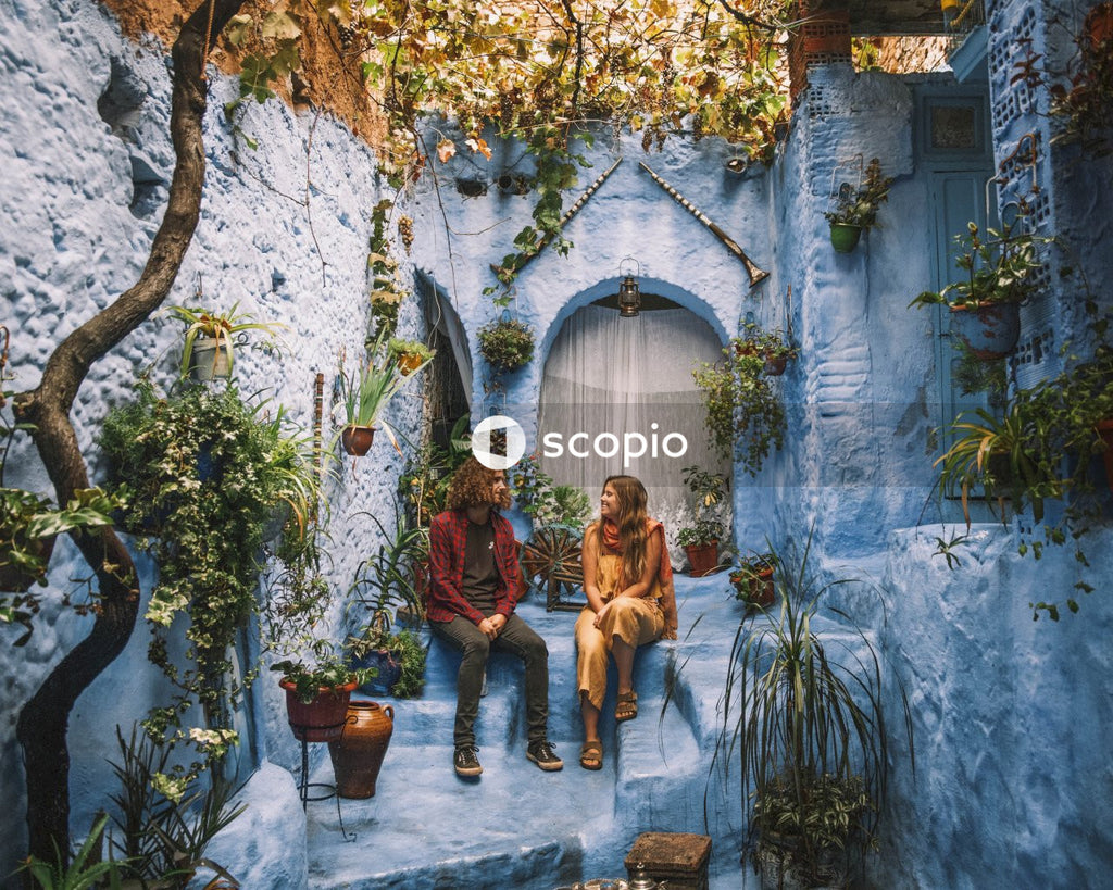 Man and woman sitting in an open space in the Blue city of Chefchaouen, Morocco