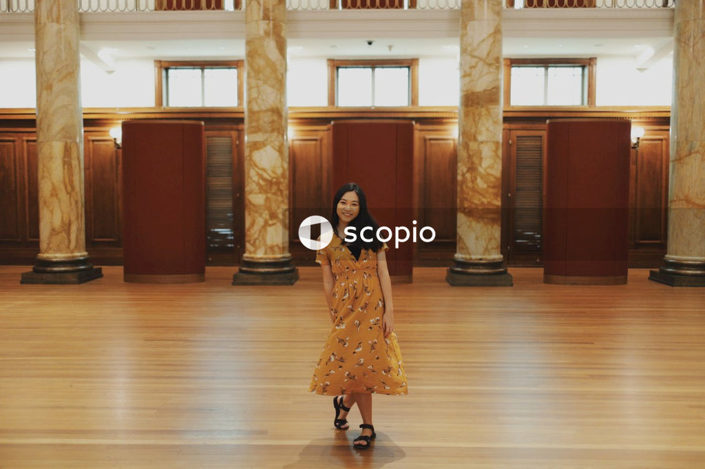 Woman in long orange dress standing in big hall