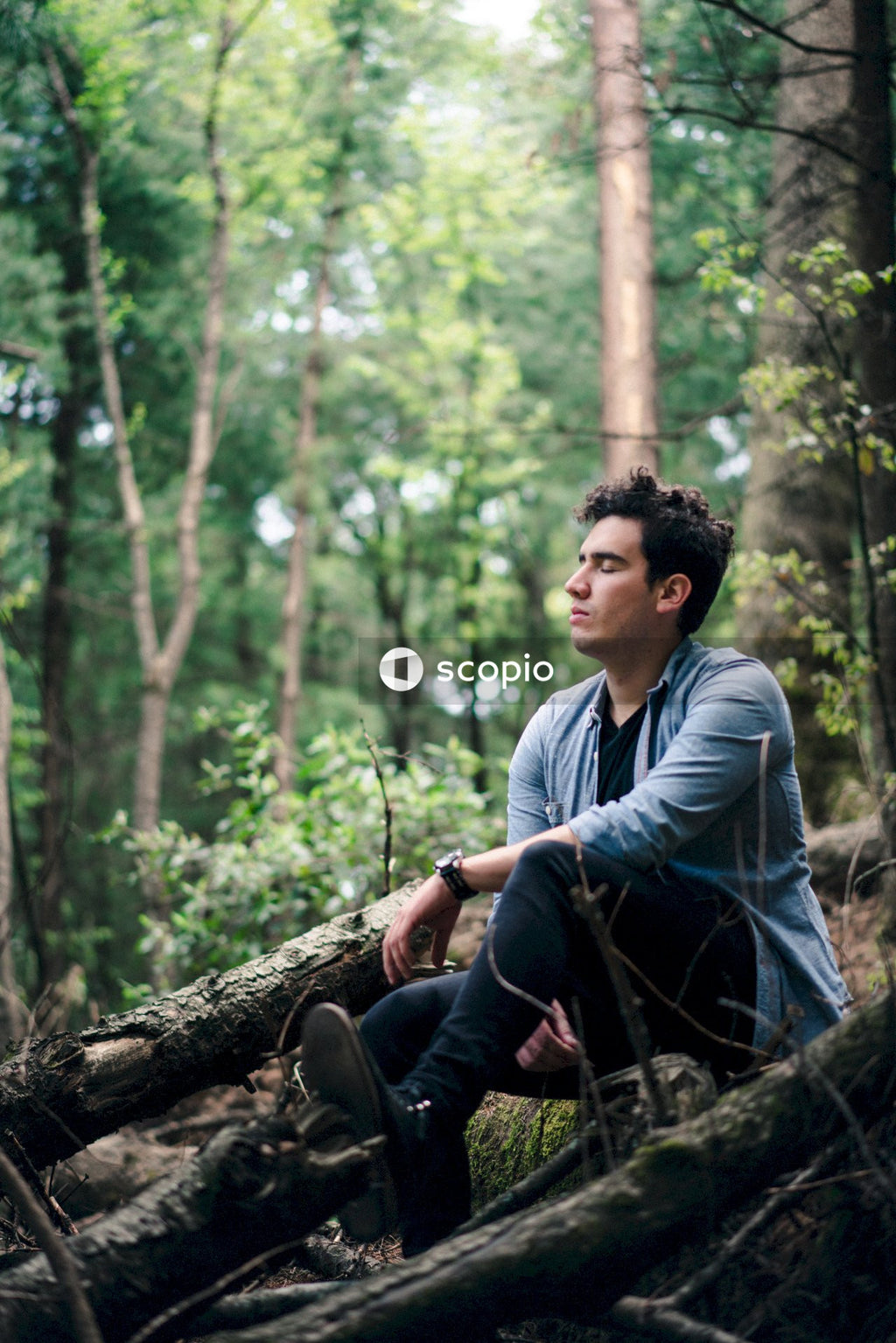 Man sitting on tree log in nature