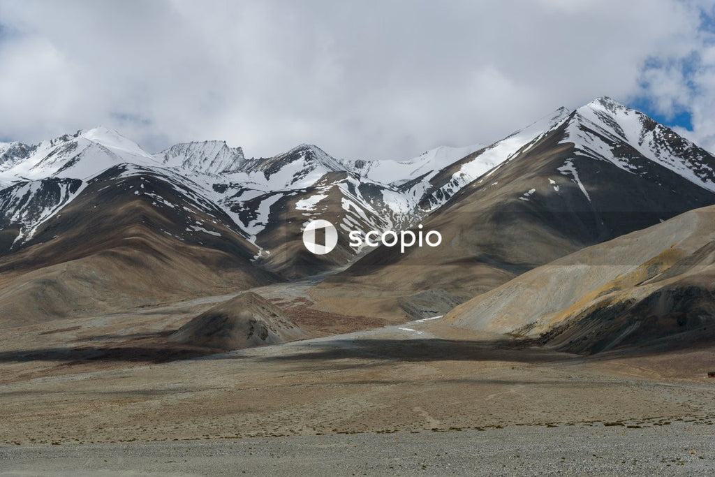 Snow covered mountain under cloudy sky