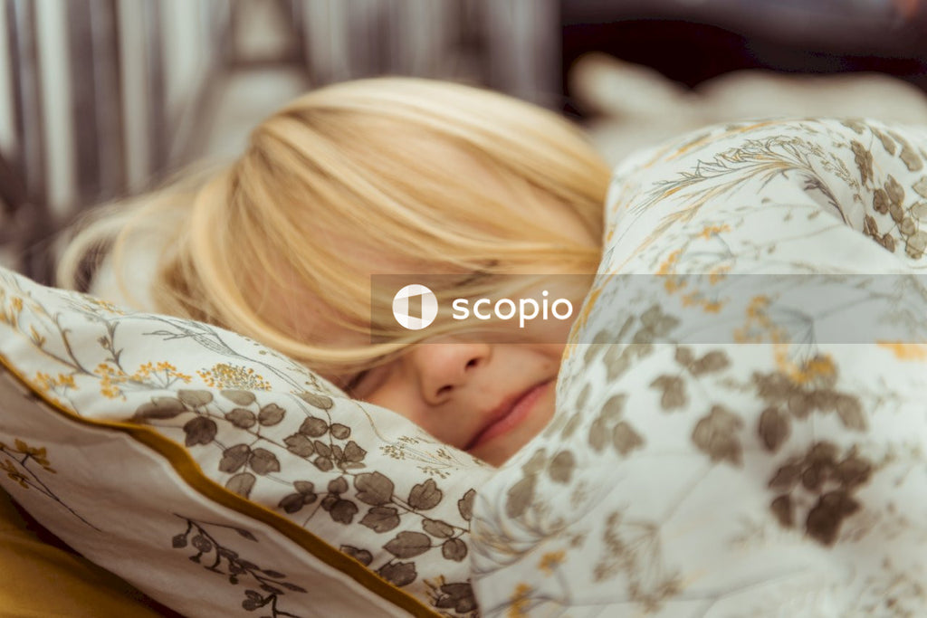 Woman in white and black floral shirt lying on bed