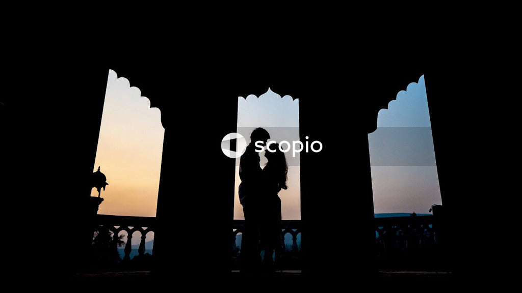 Silhouette of couple standing near body of water during sunset