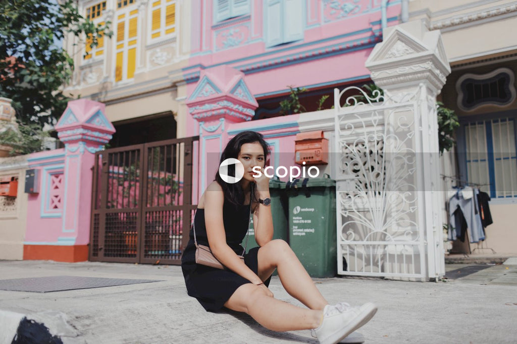 Woman on street posing near building