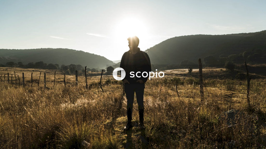 Young man in leather jacket standing on brown field